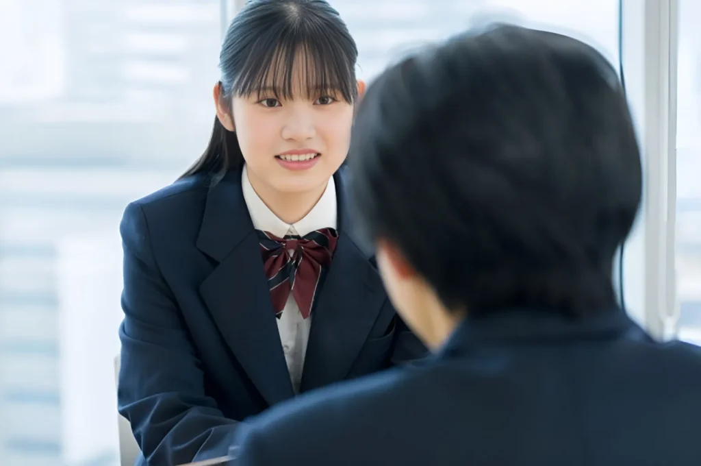 面談で大学進学を相談する女子高生